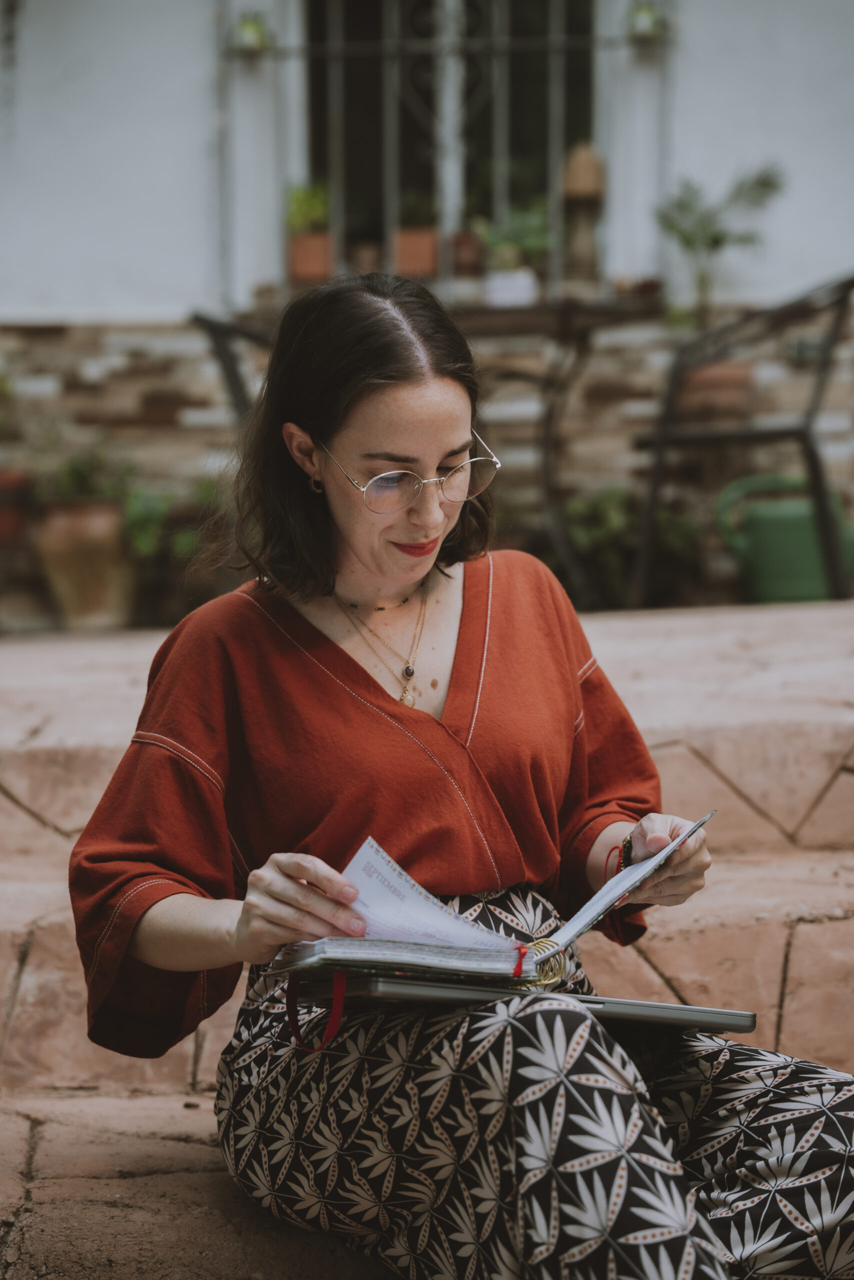 Sandra Machado hojea una libreta sentada al aire libre